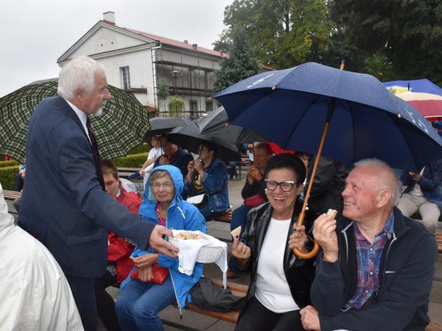 Przewodniczący Rady Gminy Włoszakowice Kazimierz Kurpisz rozdziela chleb wśród publiczności