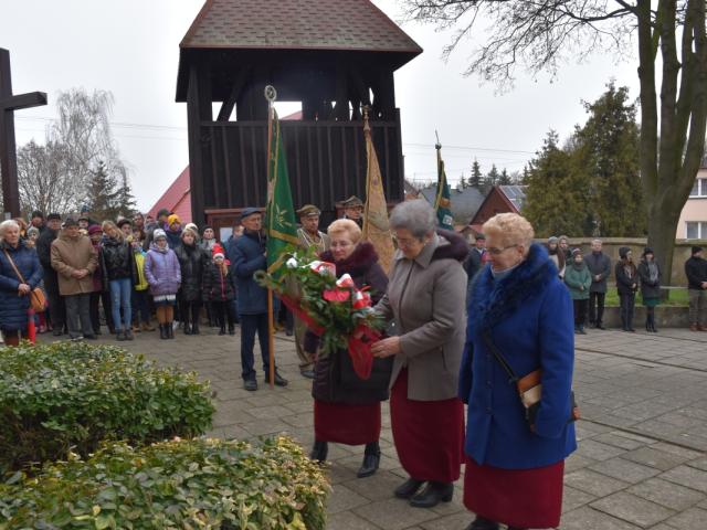 Delegacja Stowarzyszenia „Klub Złota Jesień” w Bukówcu Górnym składa wiązankę kwiatów przy tablicach pamiątkowych