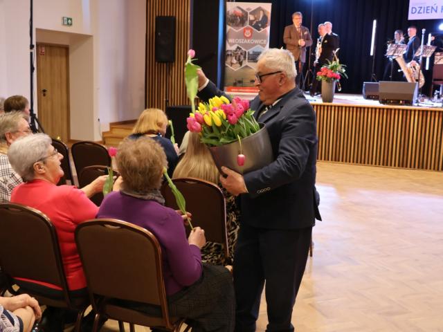 Sołtys Bukówca Tadeusz Malepszy wręcza tulipany obecnym kobietom