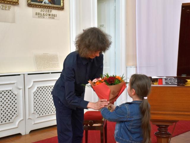 Dziewczynka z publiczności wręcza kwiaty Jakubowi Chwastyniakowi