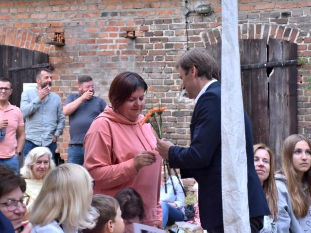 Dyrektor Gminnego Ośrodka Kultury w Wijewie Leszek Bajon wręcza kwiat uczestniczce spotkania