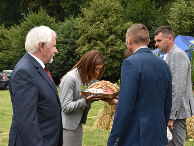Starostowie dożynek składają chleb upieczony z tegorocznej mąki na ręce sekretarz gminy Włoszakowice Karoliny Chlebowskiej